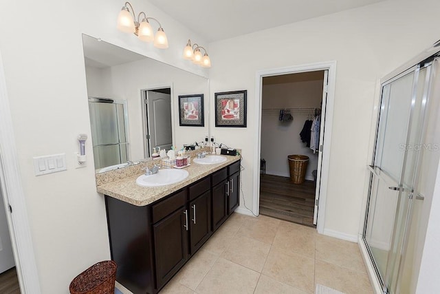 bathroom with tile patterned flooring, vanity, and a shower with door