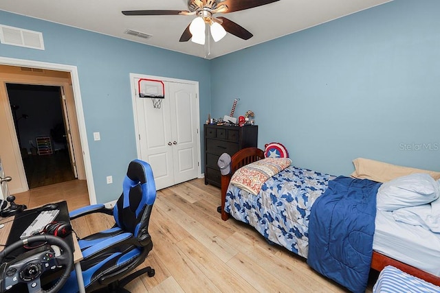 bedroom featuring ceiling fan, light wood-type flooring, and a closet