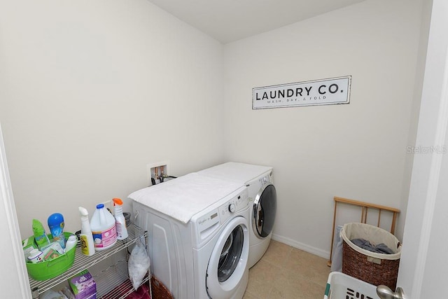 clothes washing area featuring separate washer and dryer and light tile patterned floors