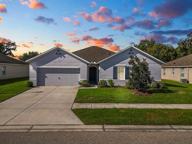 view of front of house with a garage, driveway, a front yard, and stucco siding
