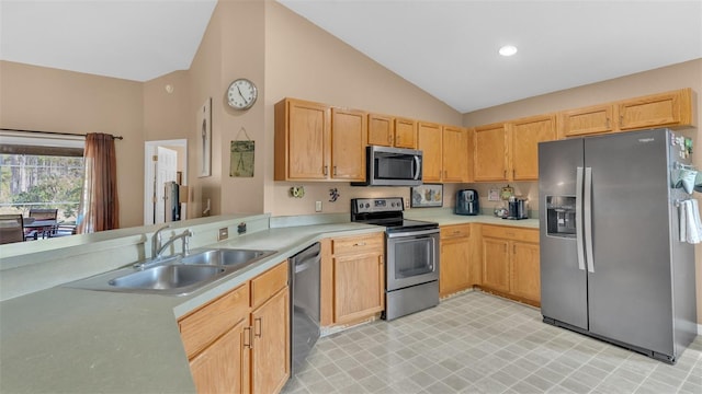 kitchen featuring appliances with stainless steel finishes, vaulted ceiling, light brown cabinetry, and sink