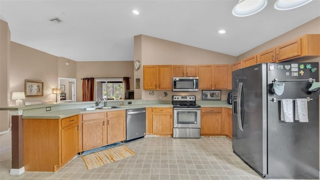 kitchen featuring lofted ceiling, kitchen peninsula, sink, and appliances with stainless steel finishes