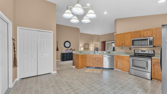 kitchen featuring sink, hanging light fixtures, appliances with stainless steel finishes, a notable chandelier, and kitchen peninsula