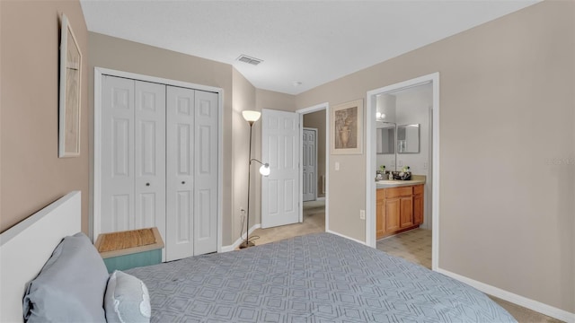 bedroom with ensuite bathroom, a closet, and light colored carpet