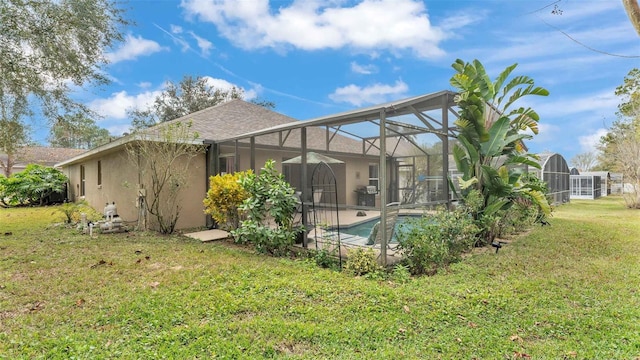 back of house with glass enclosure and a yard