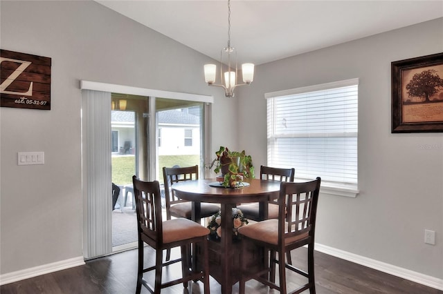 dining area with dark wood-type flooring, plenty of natural light, and a chandelier