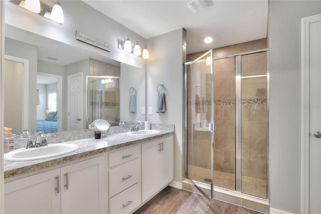 bathroom with vanity, an enclosed shower, and hardwood / wood-style flooring