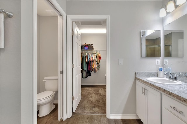 bathroom featuring vanity, wood-type flooring, and toilet