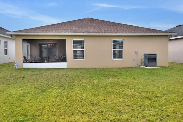 back of house featuring cooling unit, a lawn, and a sunroom