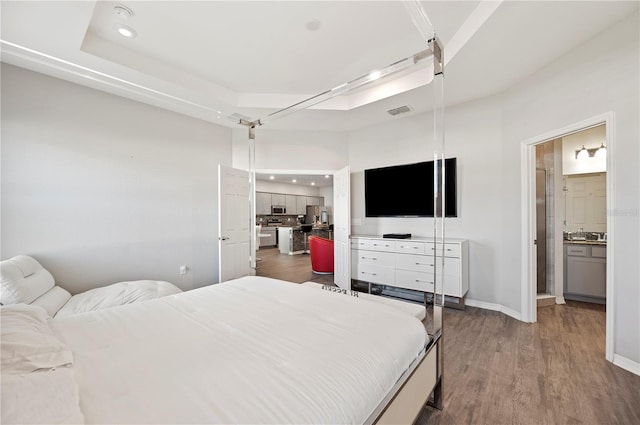 bedroom featuring dark hardwood / wood-style flooring and connected bathroom