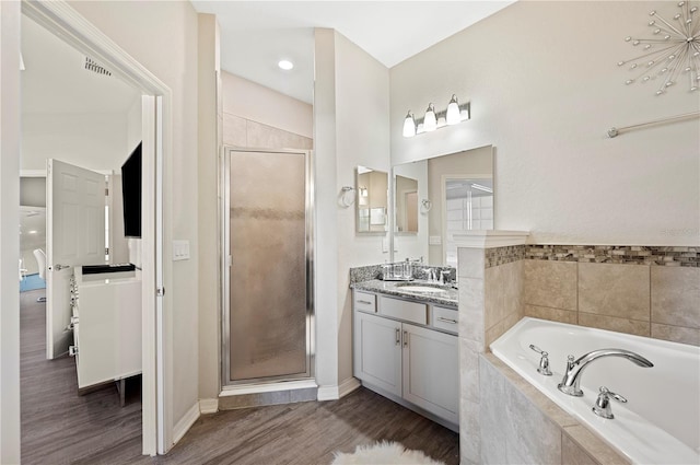 bathroom featuring hardwood / wood-style floors, vanity, and independent shower and bath