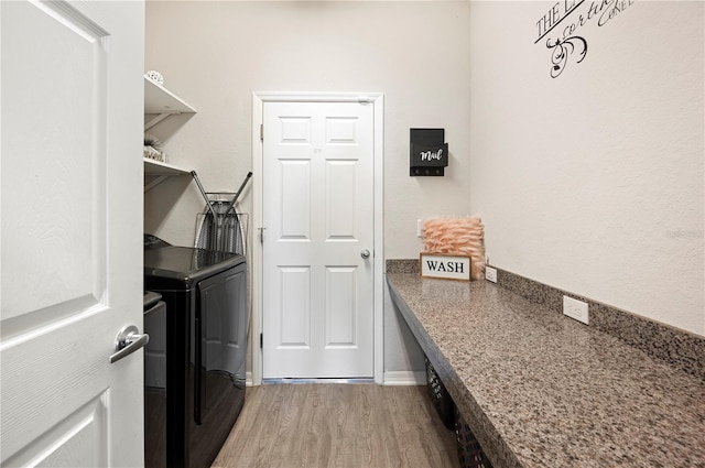 laundry room with washer and clothes dryer and hardwood / wood-style flooring