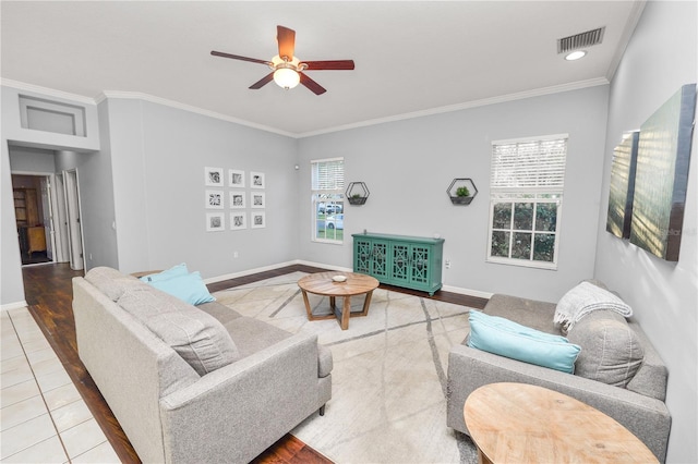 tiled living room featuring plenty of natural light, ceiling fan, and crown molding