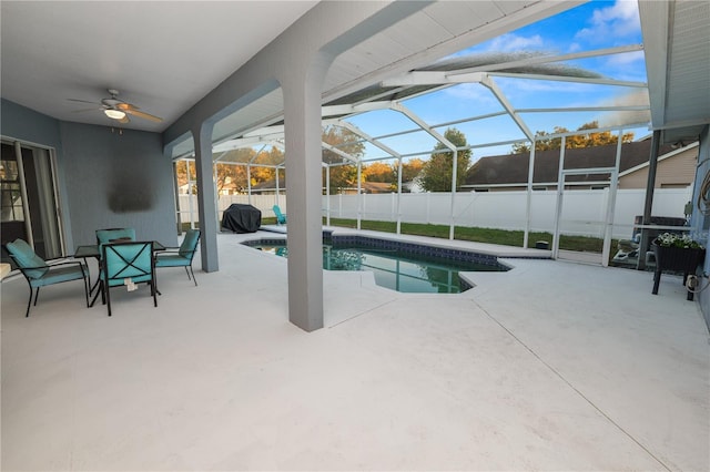 view of pool with glass enclosure, ceiling fan, and a patio area