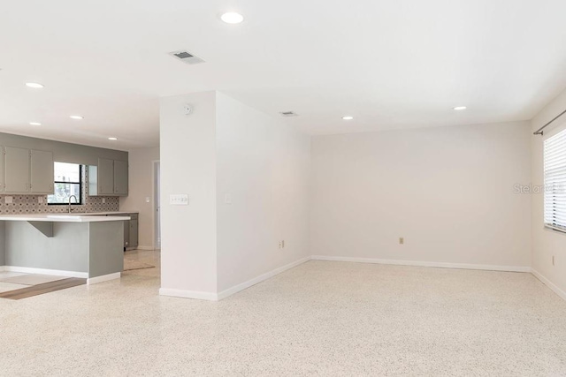 unfurnished room featuring light speckled floor, visible vents, and recessed lighting