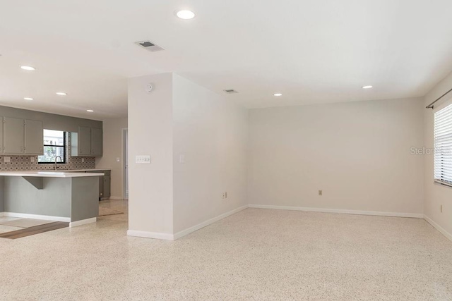 spare room with light speckled floor, baseboards, visible vents, and recessed lighting