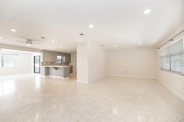 unfurnished living room with recessed lighting, ceiling fan, and baseboards