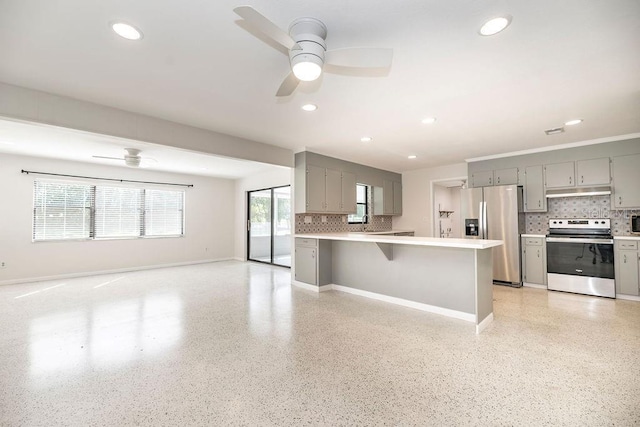 kitchen with stainless steel appliances, open floor plan, gray cabinetry, and a ceiling fan