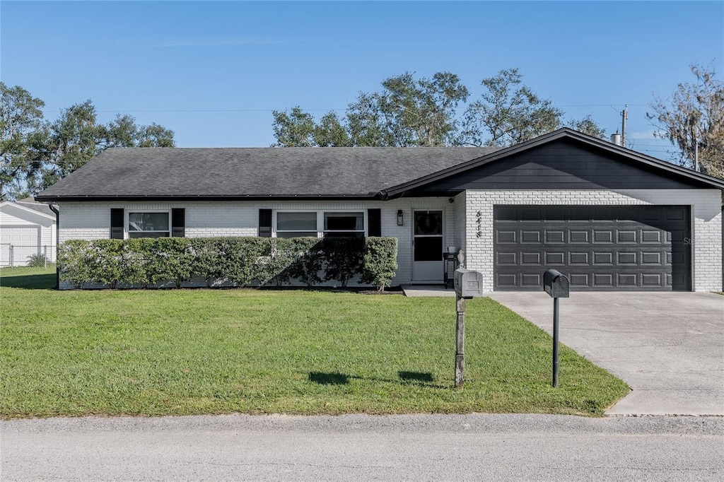 single story home featuring a front yard and a garage