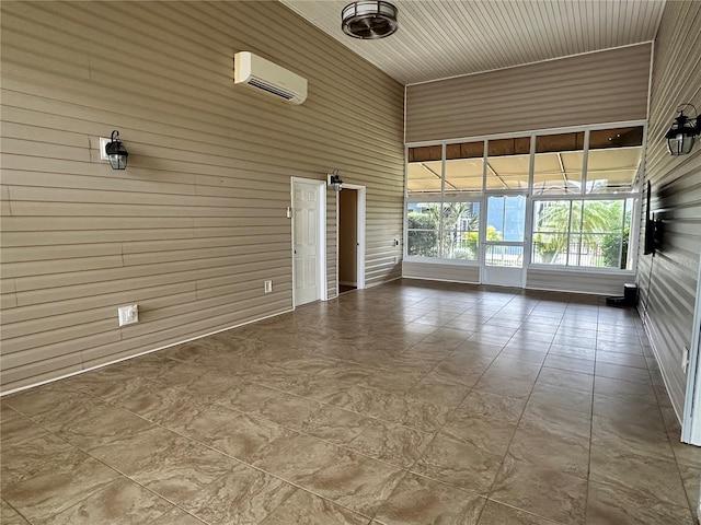 spare room with a wall mounted AC and wood walls