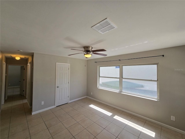 unfurnished bedroom featuring a ceiling fan, light tile patterned flooring, baseboards, and visible vents