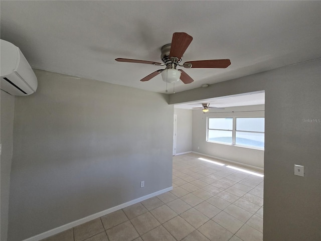 spare room featuring light tile patterned flooring, an AC wall unit, baseboards, and ceiling fan