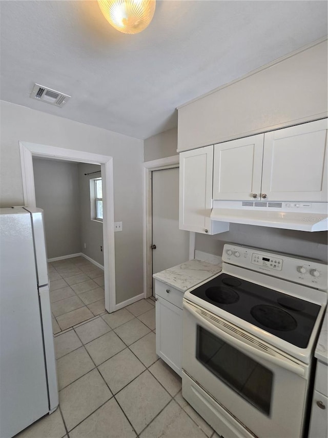 kitchen with light tile patterned flooring, visible vents, white appliances, under cabinet range hood, and white cabinetry