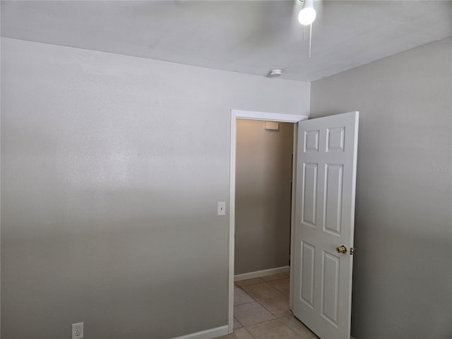 empty room with light tile patterned floors and baseboards