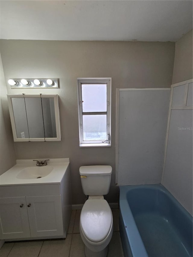 full bathroom featuring a washtub, toilet, tile patterned flooring, and vanity