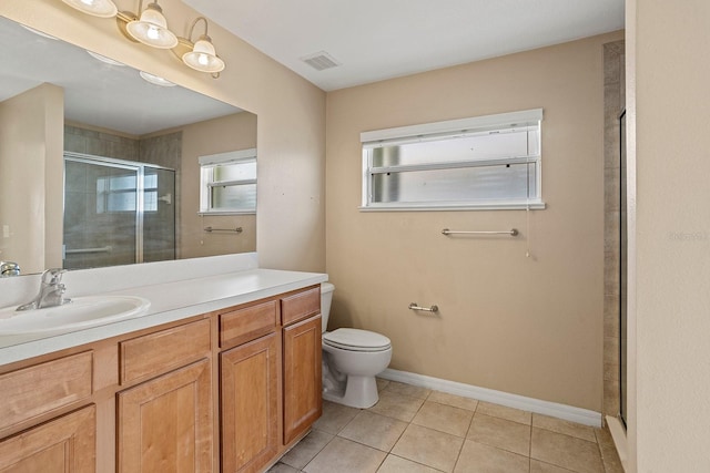 bathroom featuring toilet, vanity, tile patterned floors, and a shower with door