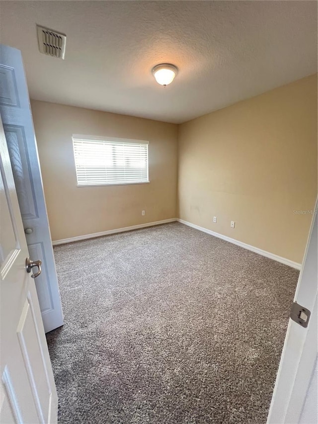 carpeted spare room featuring a textured ceiling