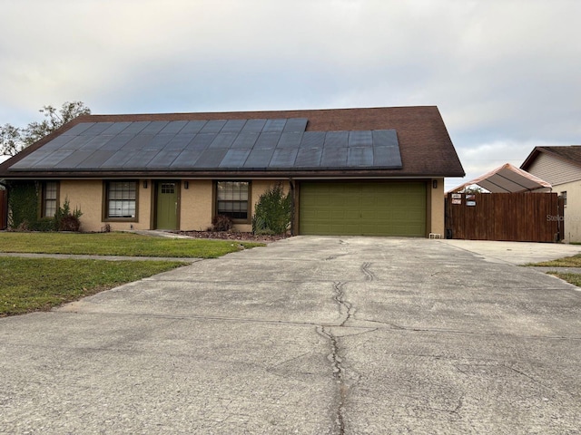 view of front of house with solar panels, a garage, and a front yard