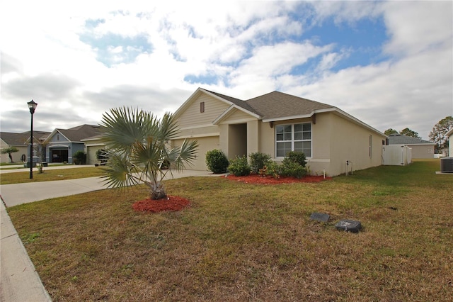 ranch-style house with a garage, a front lawn, and central air condition unit