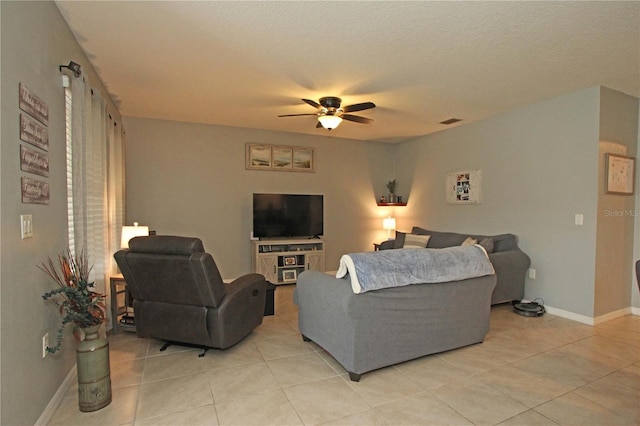 living room featuring ceiling fan, light tile patterned flooring, and a textured ceiling