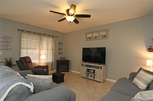 tiled living room featuring a fireplace and ceiling fan