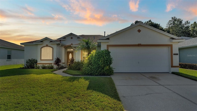 single story home with a garage and a lawn