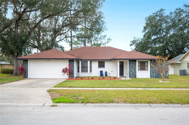 ranch-style house with cooling unit, a garage, and a front yard