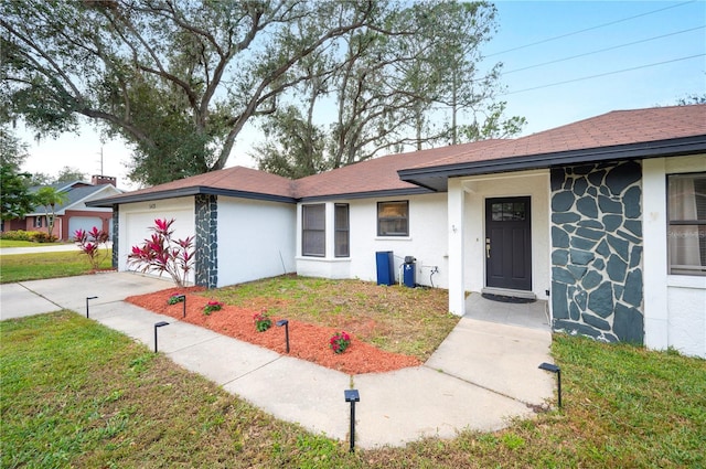 ranch-style home featuring a garage and a front lawn