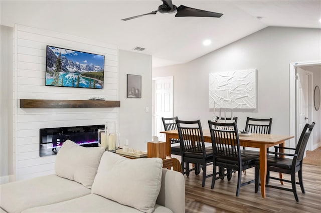 dining space featuring dark hardwood / wood-style flooring, vaulted ceiling, and ceiling fan