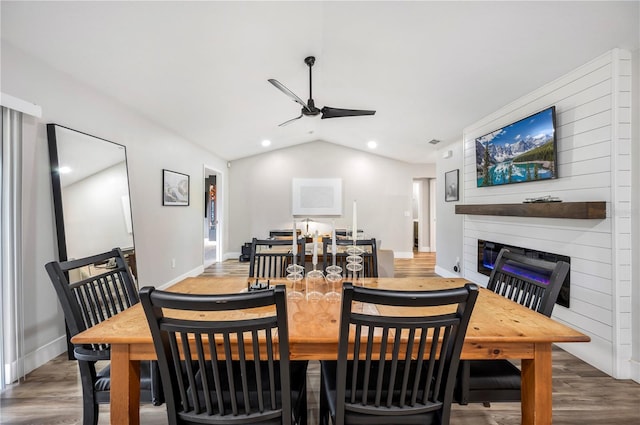 dining space featuring vaulted ceiling, wood-type flooring, and ceiling fan