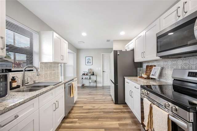 kitchen with white cabinetry, sink, and stainless steel appliances