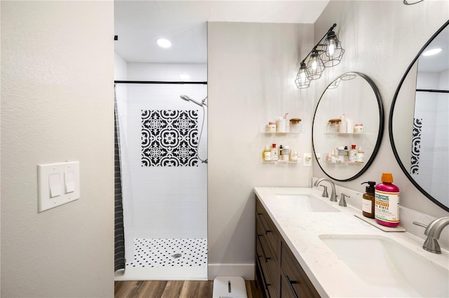 bathroom with vanity, tiled shower, and hardwood / wood-style floors