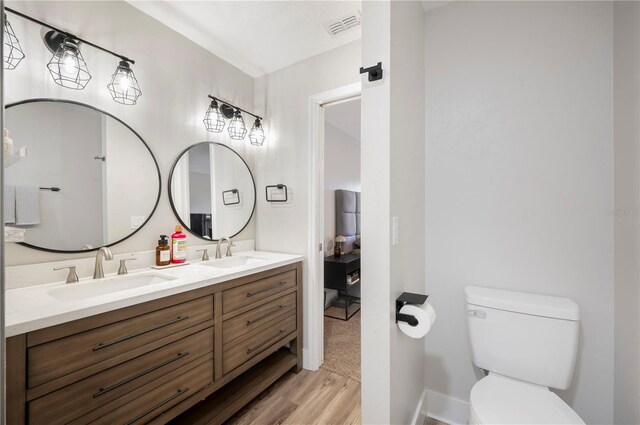 bathroom with vanity, toilet, and hardwood / wood-style floors