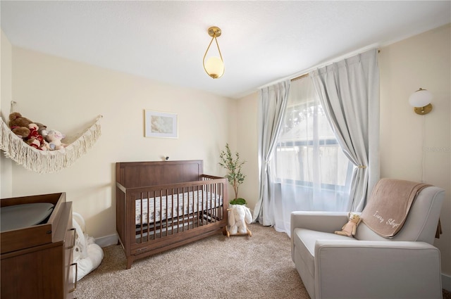 carpeted bedroom featuring a crib