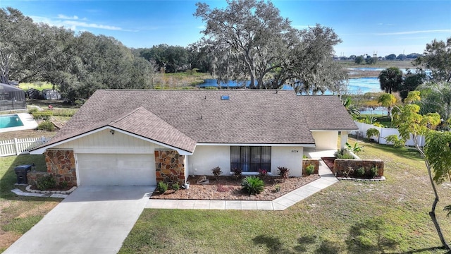 view of front of house with a water view, a garage, and a front lawn