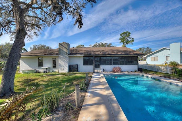 view of swimming pool with a lawn and a sunroom