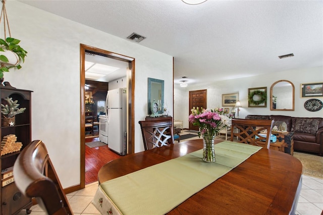 tiled dining area featuring a textured ceiling