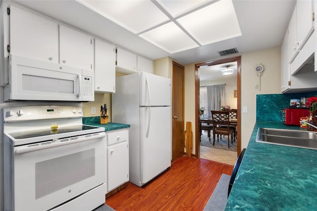 kitchen featuring hardwood / wood-style floors, white cabinetry, white appliances, and backsplash