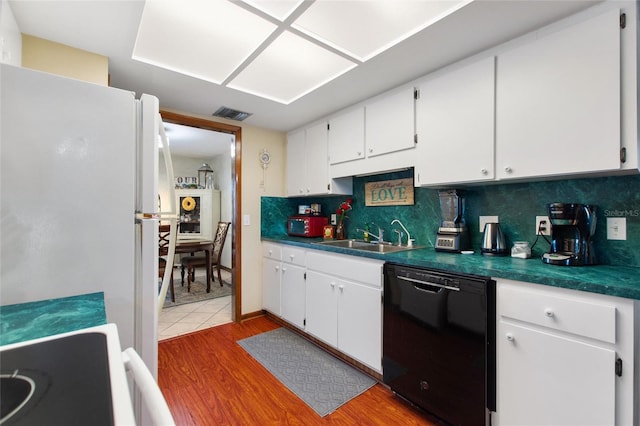 kitchen with dishwasher, backsplash, sink, white fridge, and white cabinetry