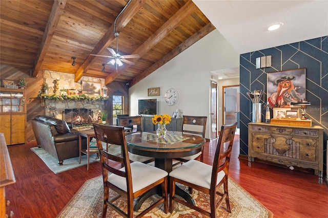 dining room with beamed ceiling, wood-type flooring, a fireplace, and wooden ceiling